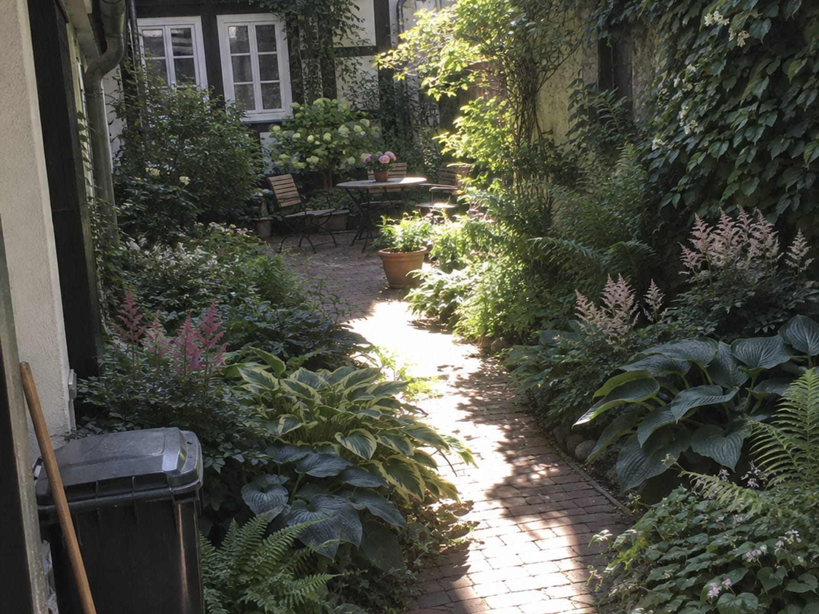 Schattiger Hinterhofgarten mit Klinkerweg und Hortensien hinter einem Fachwerkhaus in der Northeimer Altstadt